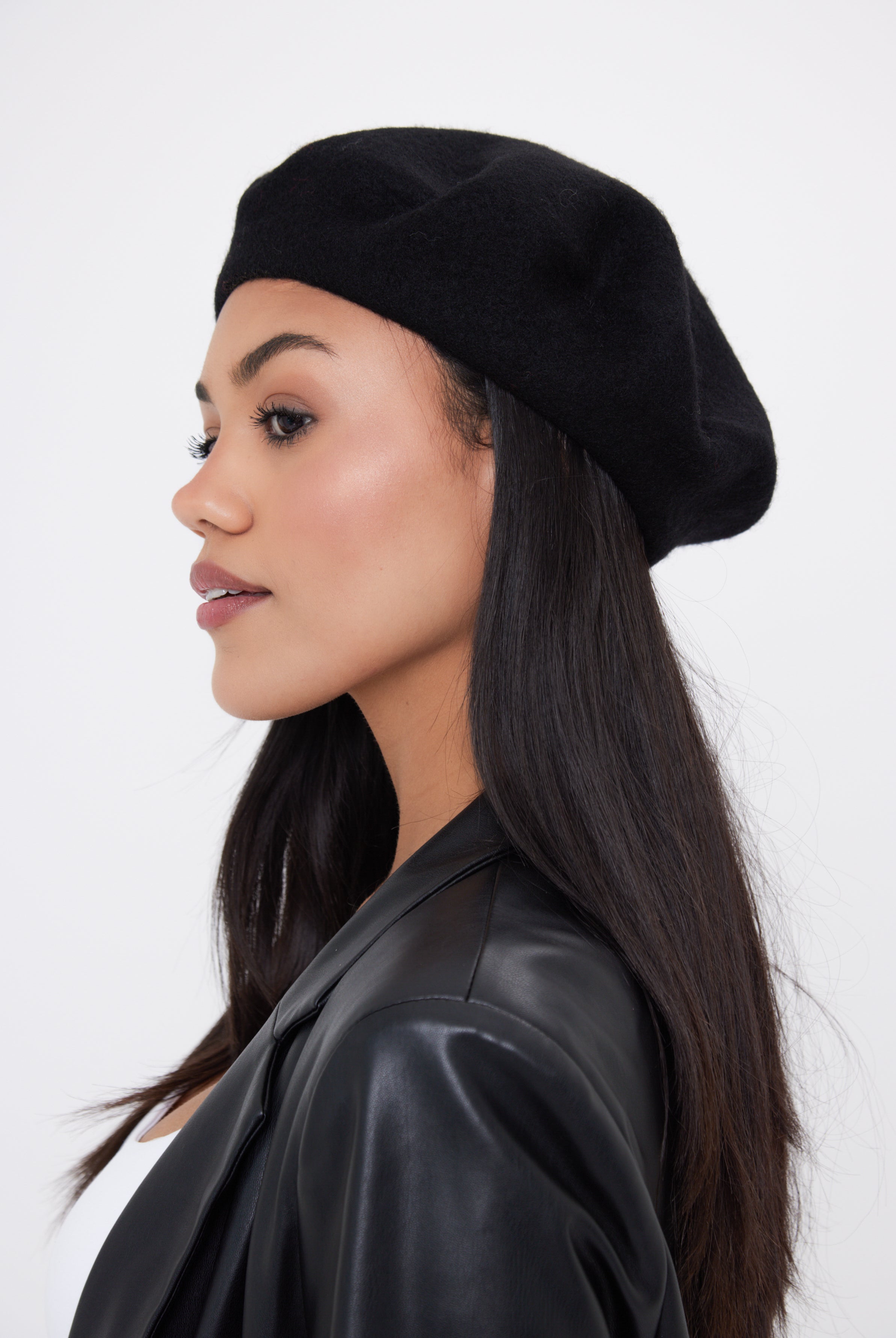 Woman wearing a black beret against a white background