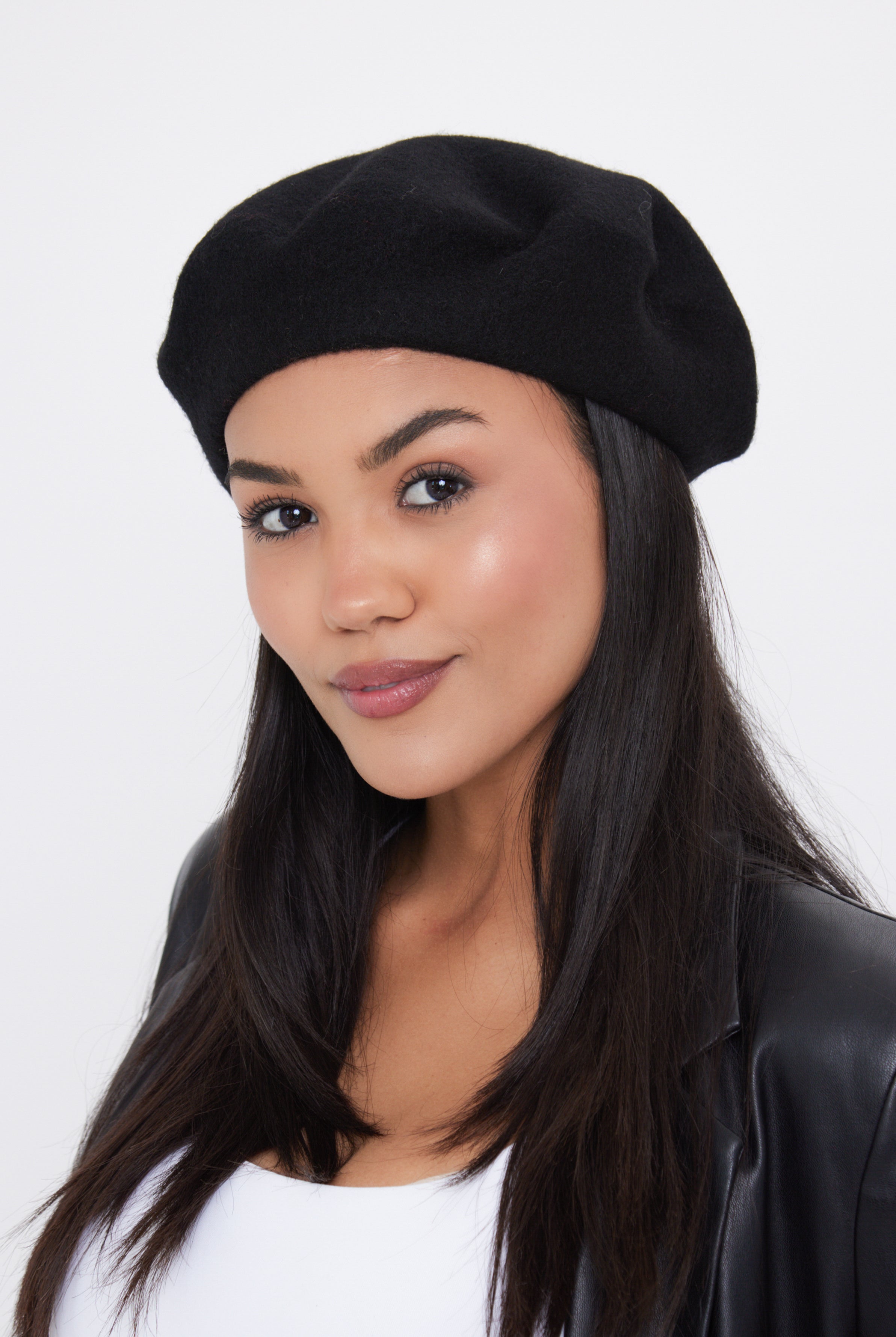 Woman wearing a black beret against a white background