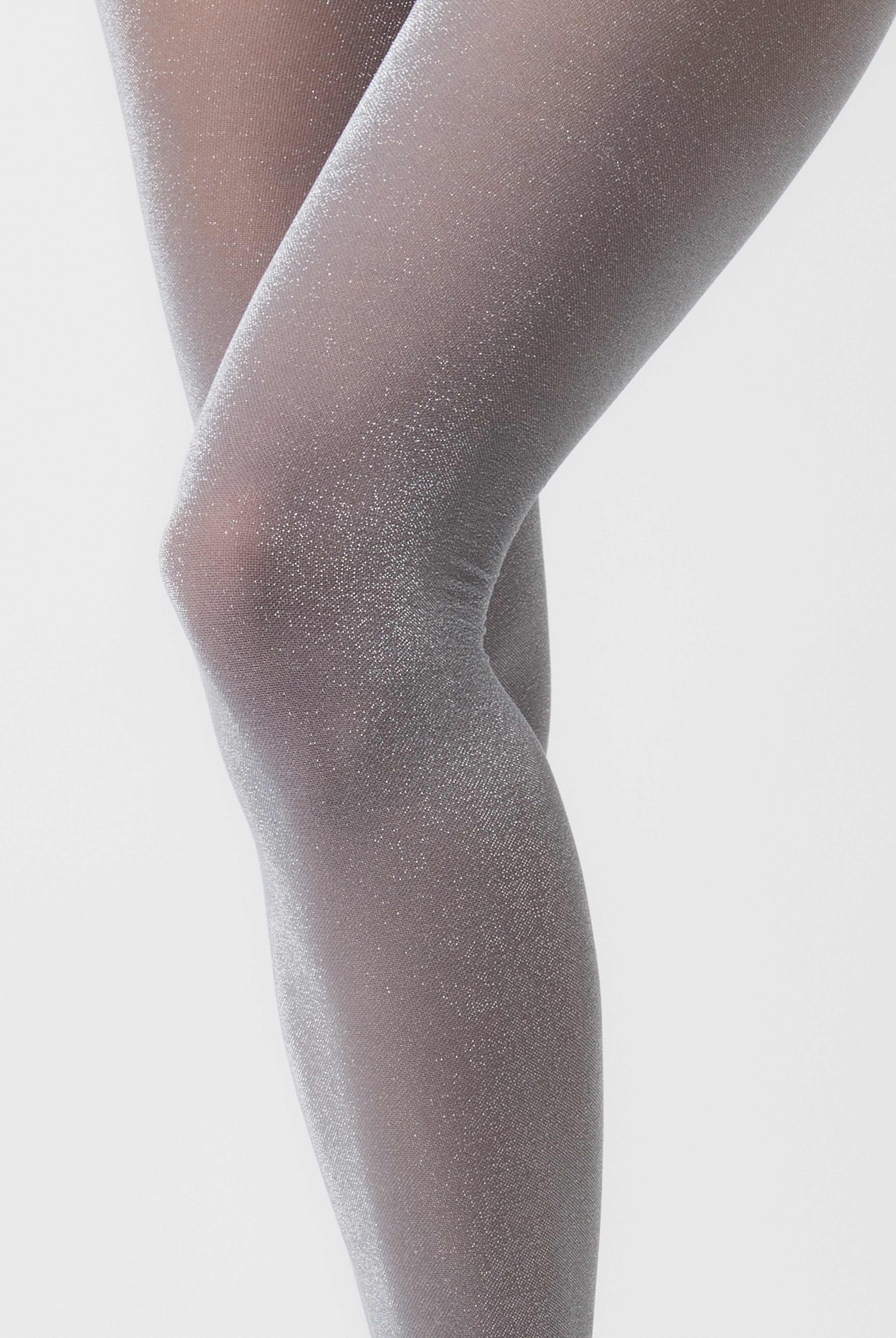 Close-up of a person wearing sheer gray tights on a light gray background