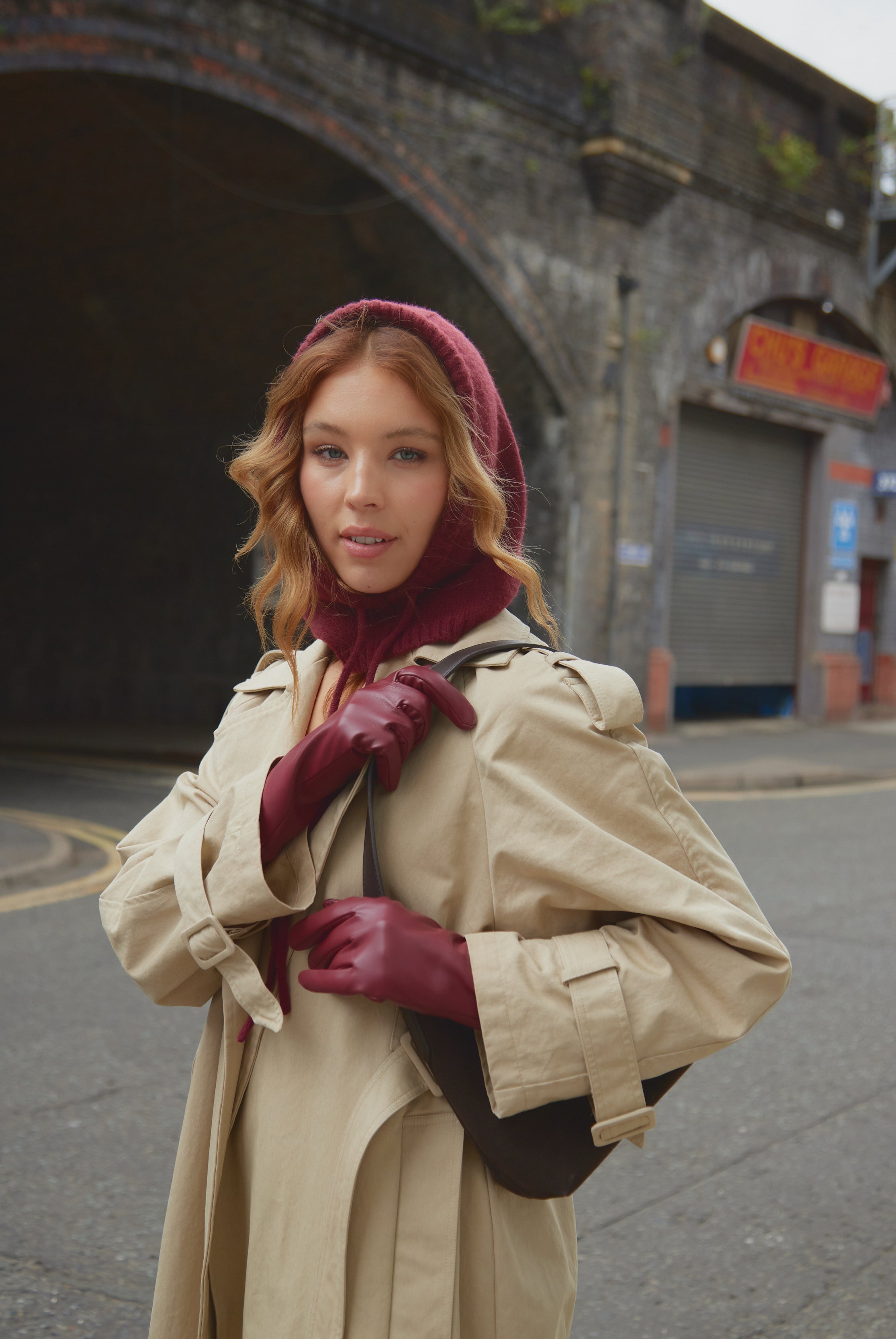 girl wearing red gloves and red balaclava in trench coat