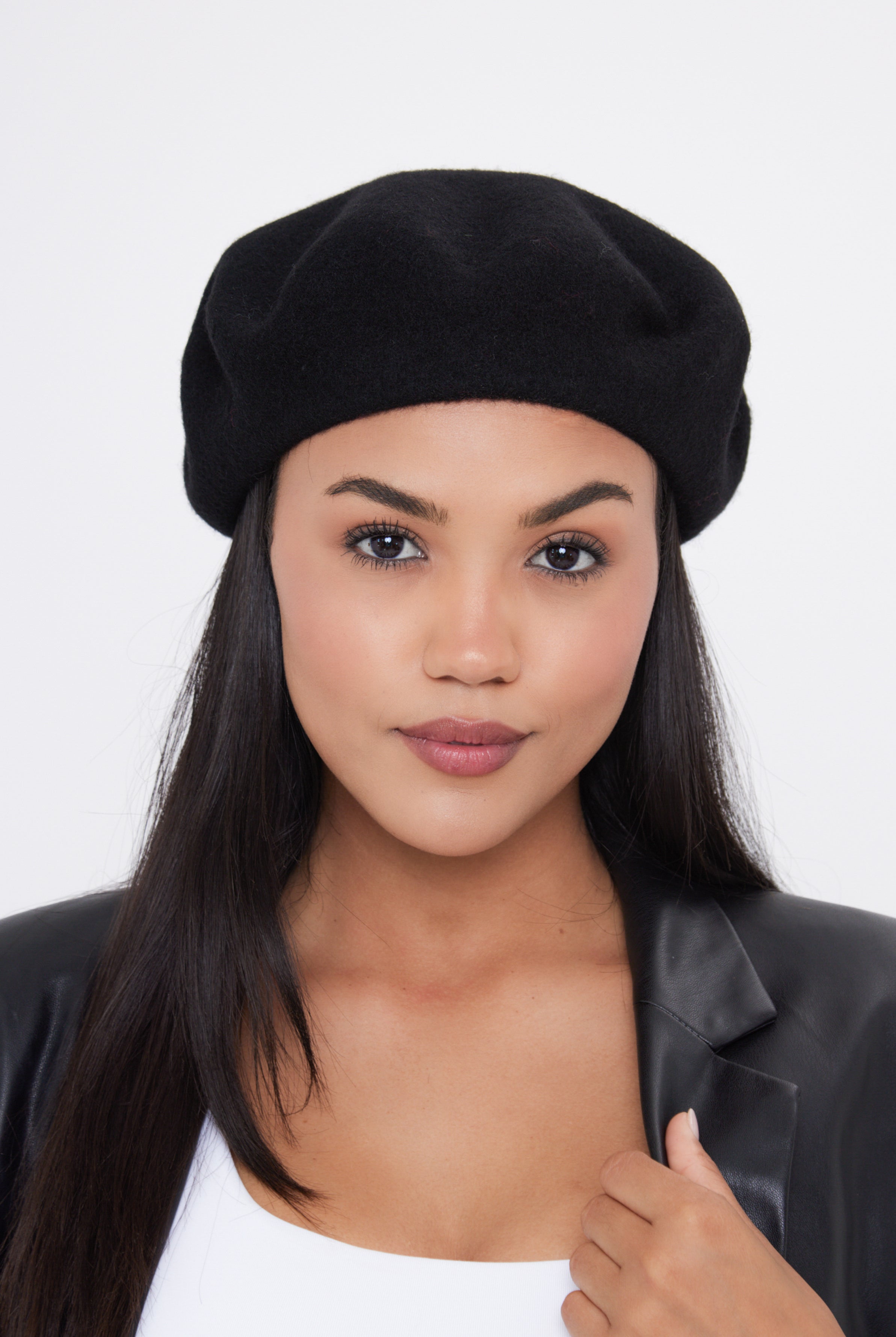 Woman wearing a black beret against a white background