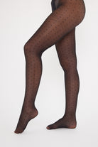 Black polka dot tights on a white background