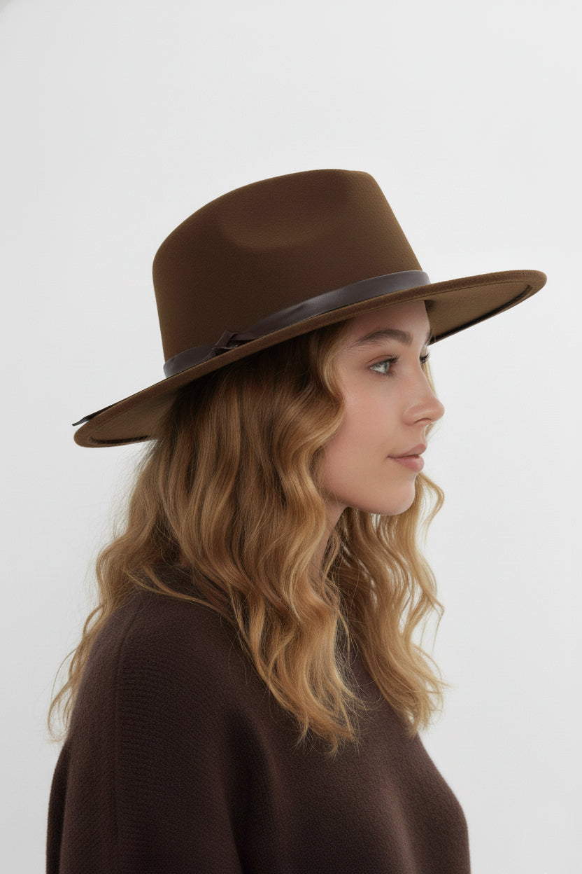 Woman wearing a brown fedora hat against a white background