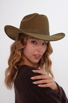 Woman wearing a brown cowboy hat against a white background