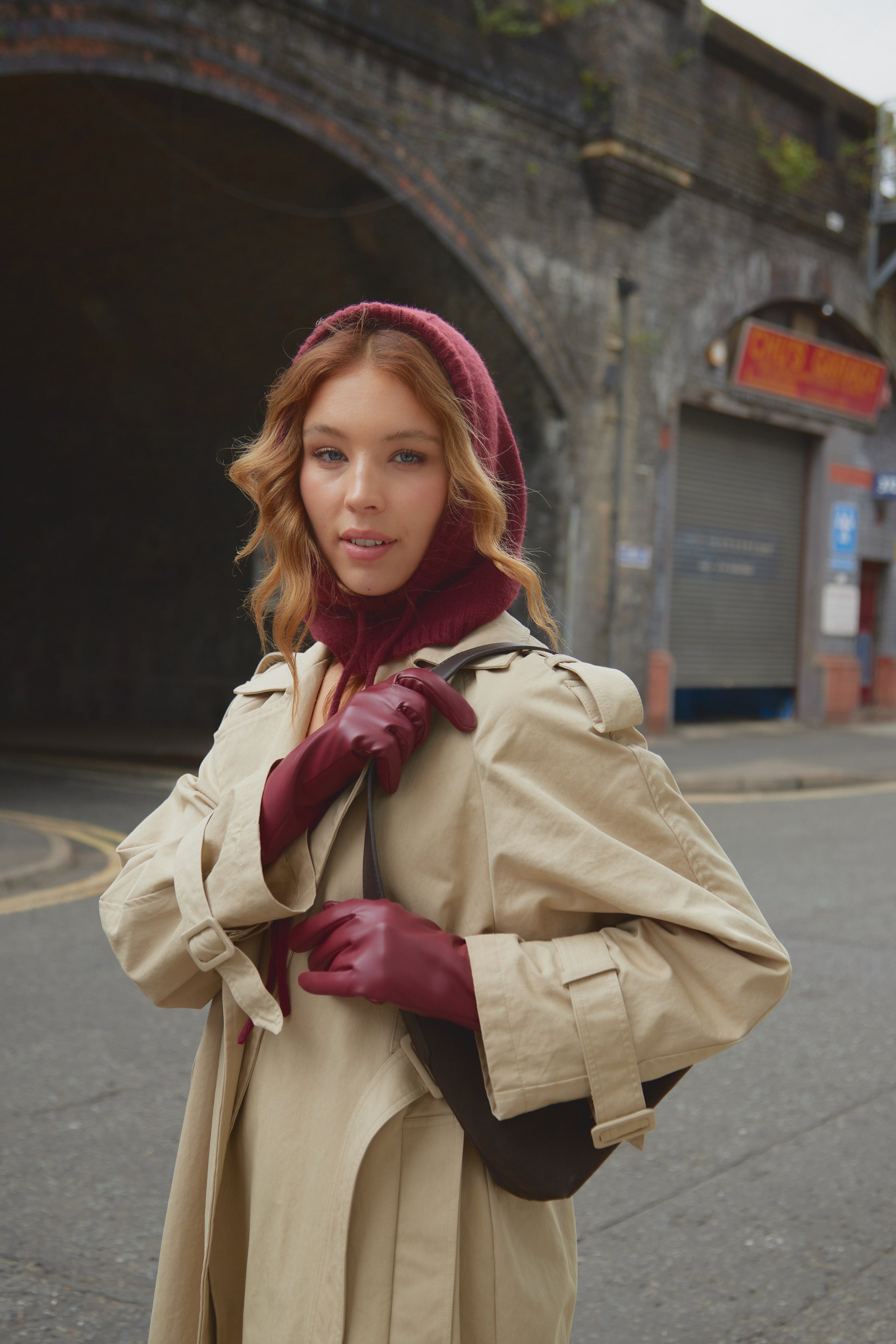 girl wearing red gloves and red balaclava in trench coat