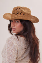 Woman wearing a straw hat against a plain background