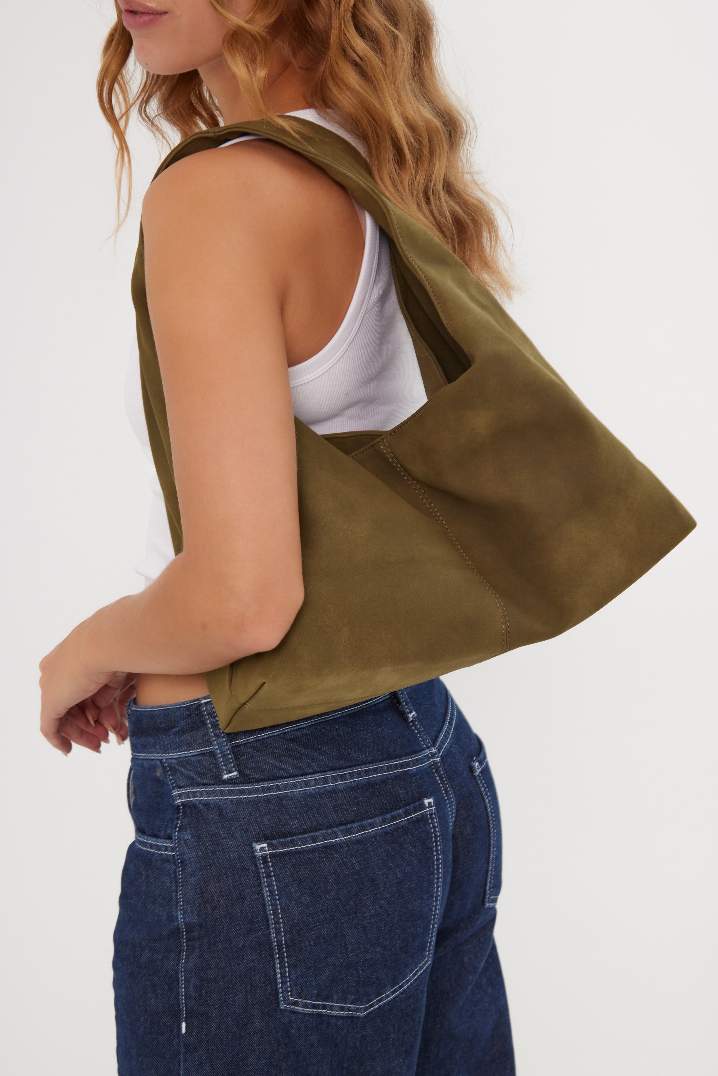 Person wearing a green bag over one shoulder on a white background