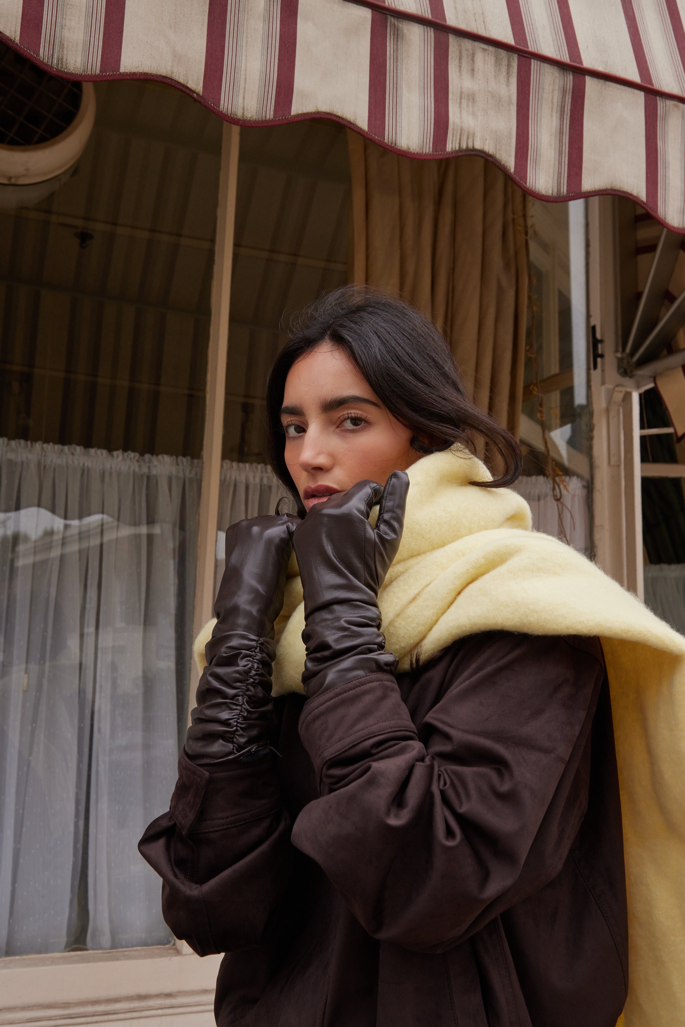 Woman in a vintage setting wearing a coat and ruched gloves