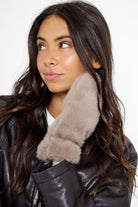 Model wearing fluffy Fur Mittens in Taupe and a brown leather jacket and jeans
